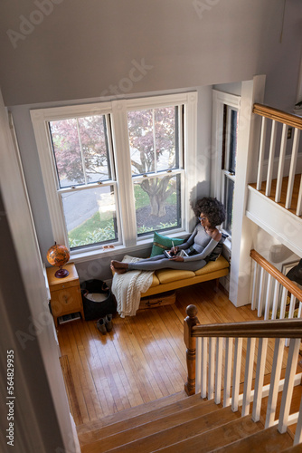  Girl at apartment drawing with ipad tablet computer in cozy nook  photo