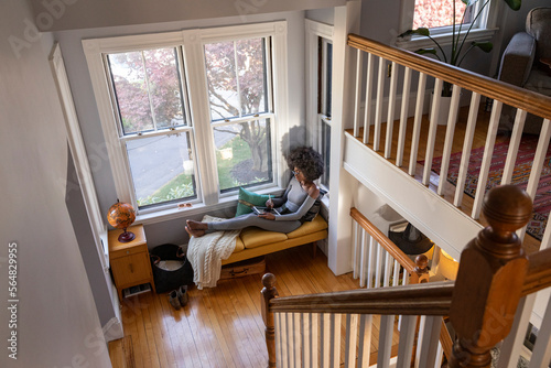 black Girl at home drawing  with ipad tablet computer in cozy nook  photo