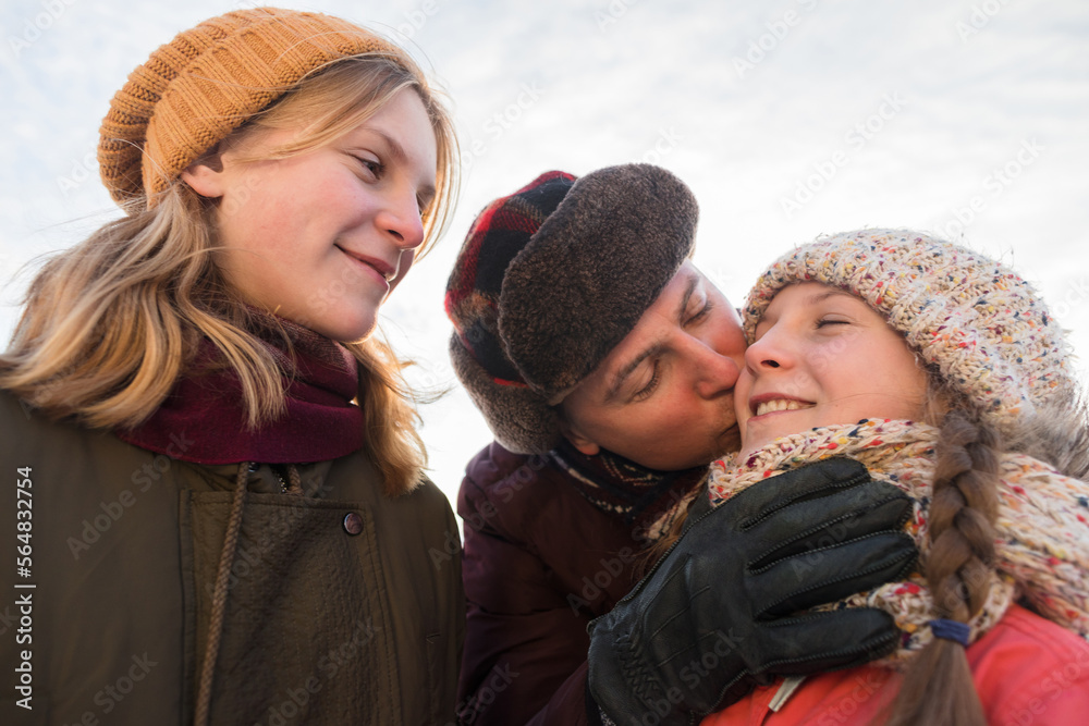 Father kisses his daughter in winter Father kisses his daughter in winter