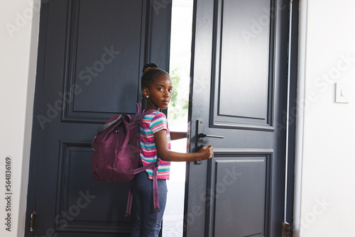 Portrait of african american girl wearing backpack, leaving for school, with copy space photo