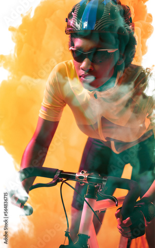 Confident african american female cyclist wearing glasses and helmet riding bike on smoky background