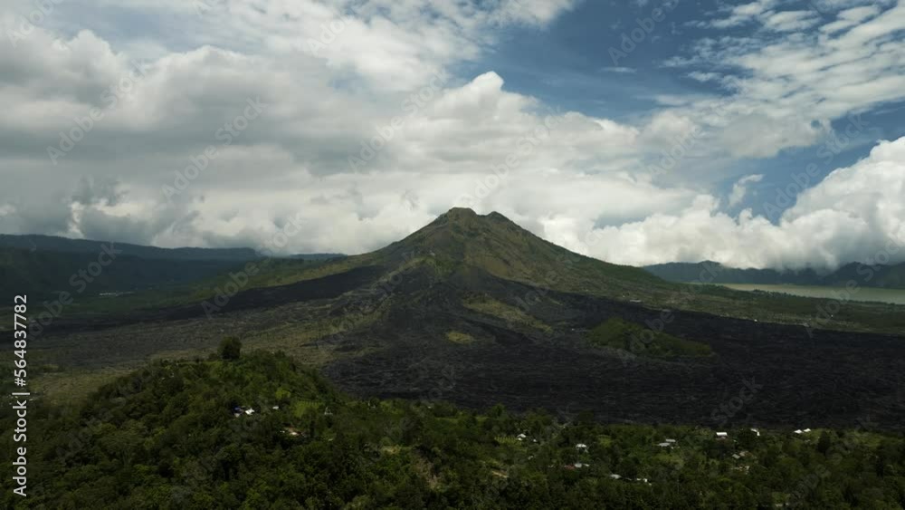 Volcano, mountains, sky with clouds, traces of lava on the ground. Aerial view of Mount Batur Volcano in Kintamani. Bali volcano, also referred to as Kintamani is popular sightseeing destination in Volcano, mountains, sky with clouds, traces of lava on the ground. Aerial view of Mount Batur Volcano in Kintamani. Bali volcano, also referred to as Kintamani is popular sightseeing destination in