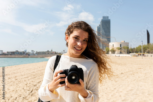 Young travel photographer by the beach photo