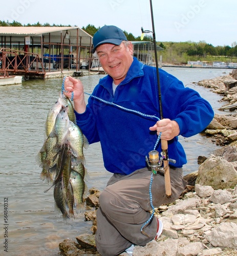 An angler with a stringer of crappies photo