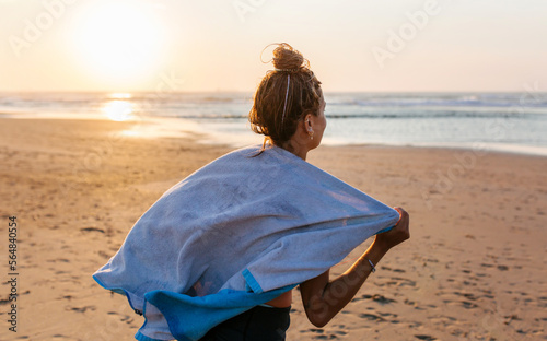Woman drying herself with towel after surfing