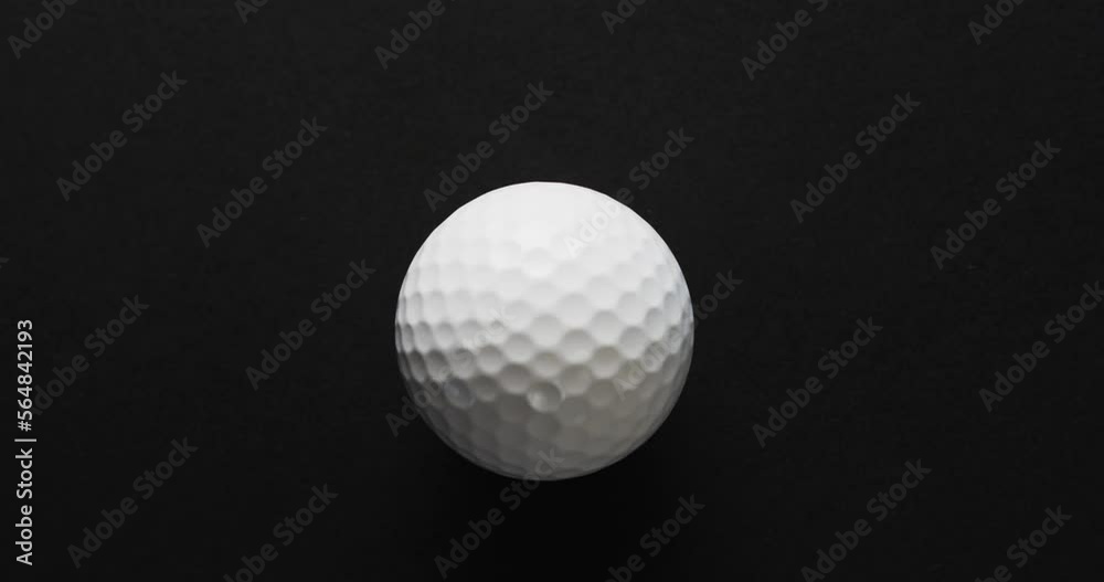 Close up of golf ball on black background, copy space, slow motion