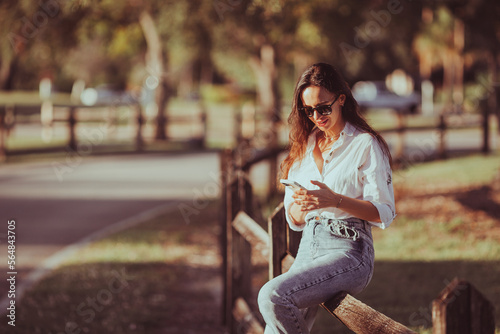 Young woman using mobile phone outdoor in the park