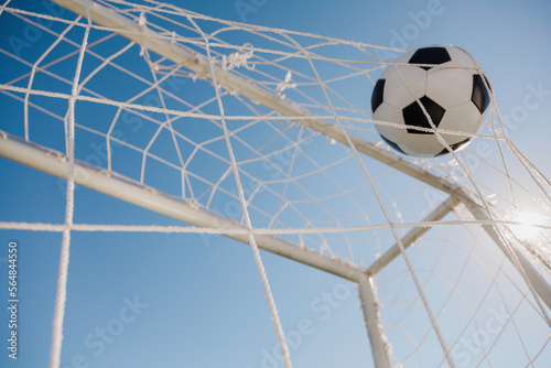 soccer ball in the net on the blue sky background photo