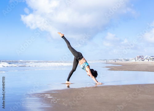 A woman practicing yoga on the water at the beach