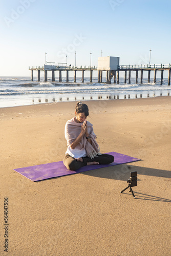 Slim woman yoga instructor giving online yoga training in a mobile
