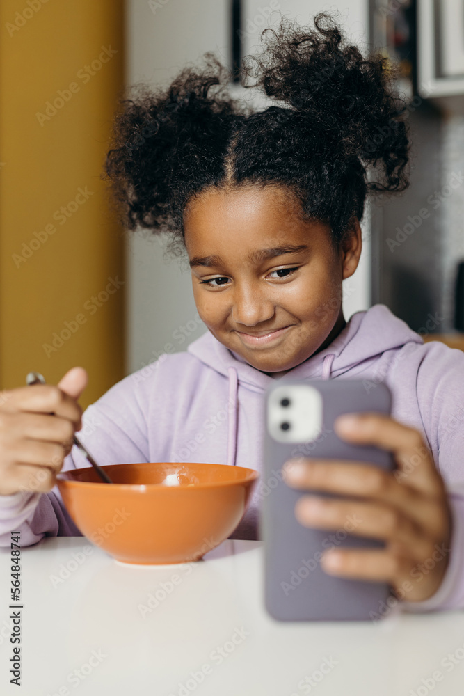 Cheerful black girl browsing social media on cellphone Cheerful black girl browsing social media on cellphone