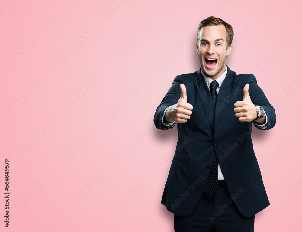 Happy excited businessman showing two thumbs up like hand gesture, in black confident suit, over rose pink color background. Very cheerful man. Copy space for ad, slogan or text. Happy excited businessman showing two thumbs up like hand gesture, in black confident suit, over rose pink color background. Very cheerful man. Copy space for ad, slogan or text.