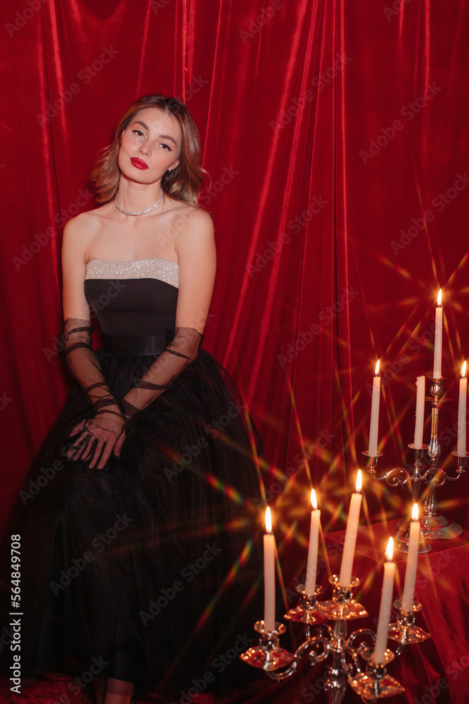 Pretty woman in black dress posing with candles Pretty woman in black dress posing with candles