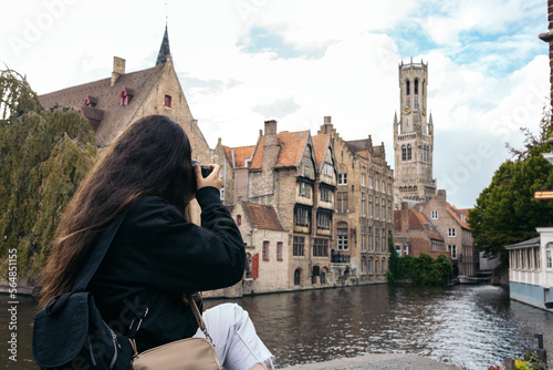 Woman taking photos with camera in Bruges, Belgium photo