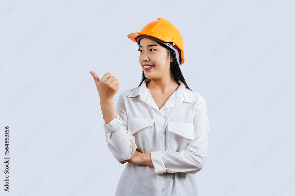 Young female engineer in helmet stand with thumb up posture Young female engineer in helmet stand with thumb up posture