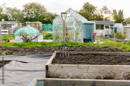 Allotment garden with garden fork stuck in soil