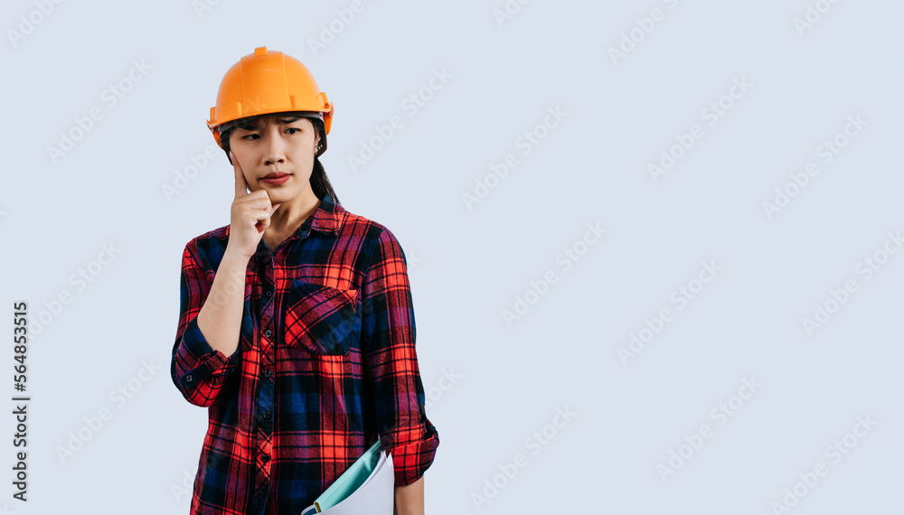 Young female engineer in helmet stand with thoughtful posture