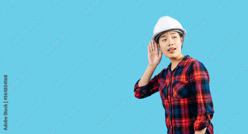 Young female engineer hand over ear to making hear gesture Young female engineer hand over ear to making hear gesture