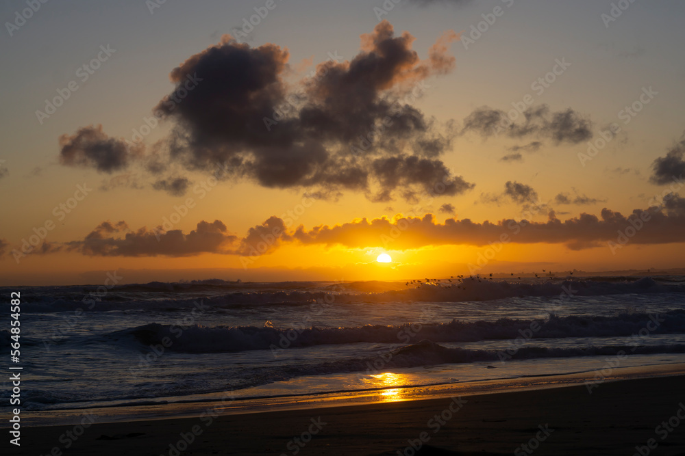 Sunset on the beach. Paradise beach. Tropical paradise, clear water. Seascape in early evening, sunrise over the ocean. Nature landscape. Orange and golden sunset sky. 