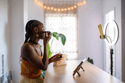 Glad beauty blogger applying rouge