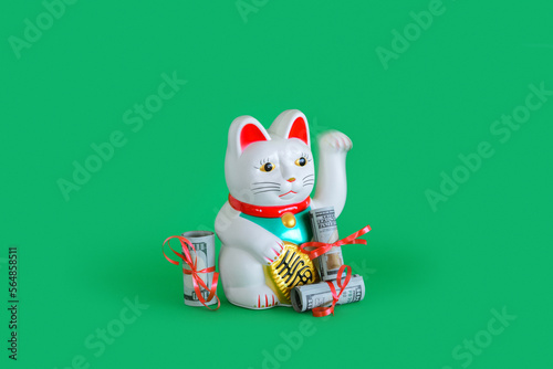 Chinese lucky waving cat with money around it photo