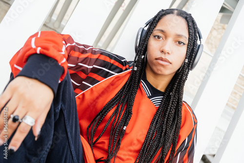 self-confident and expressive woman with long braids listening music photo