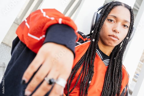 self-confident and expressive woman with long braids listening music photo