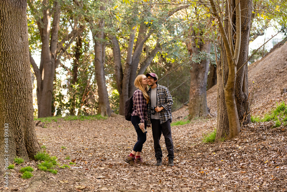 Woman Kisses Man On The Cheek During A Nature Hike Woman Kisses Man On The Cheek During A Nature Hike