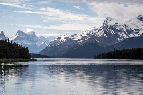 Scenic view of Maligne Lake by snowcapped mountains against cloudy sky at Jasper National Park