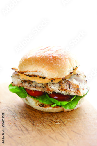 High angle view of grouper sandwich on wooden table against white background photo