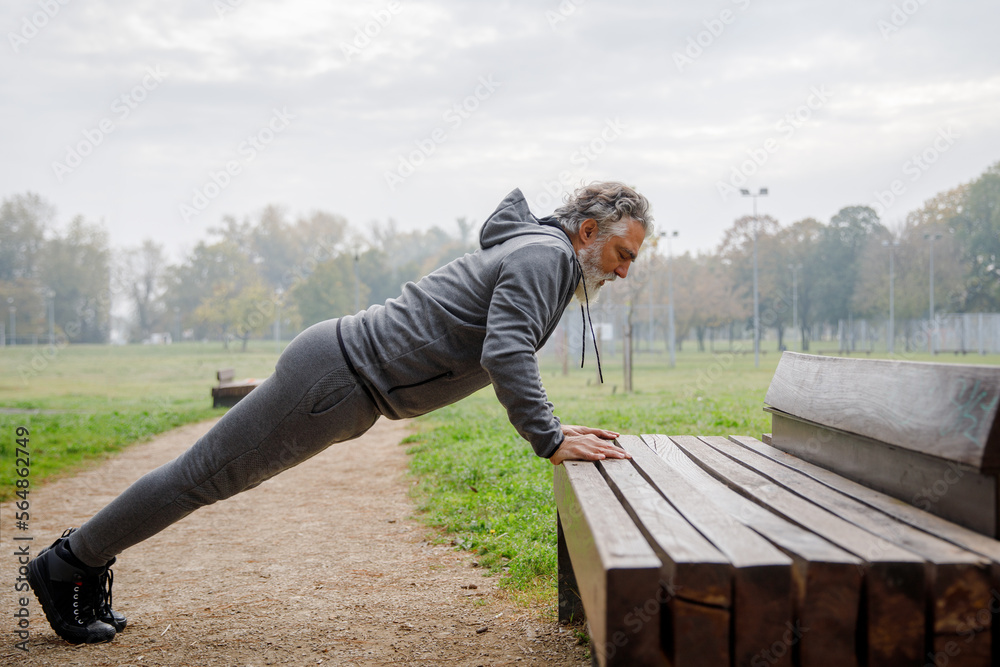 Senior sportsman doing push up exercise on bench Senior sportsman doing push up exercise on bench