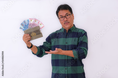 Asian man standing and showing off some cash money and car ownership document photo