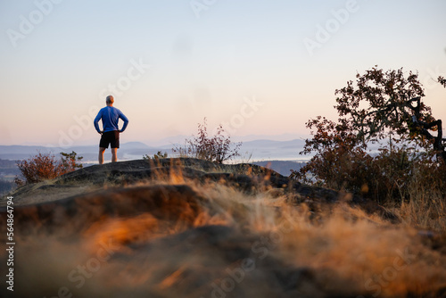 Tired runner man on top of hill after summiting.