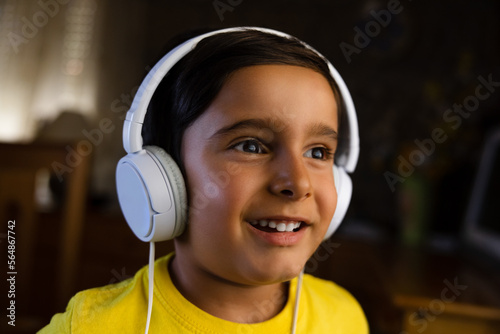 Smiling kid in headphones listening to music