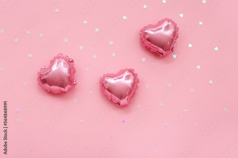 Heart shaped balloons and sequins on pink background. Valentine's Day celebration