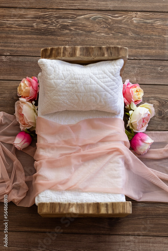 Newborn photo shoot set up with prop bed and wood backdrop