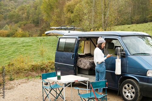 woman camping on van in the countryside photo