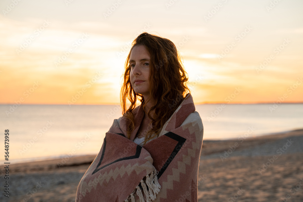 woman with blanket at beach at sunset woman with blanket at beach at sunset