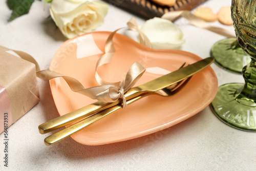 Table setting with cutlery and beautiful bow on white background. Valentine's Day celebration