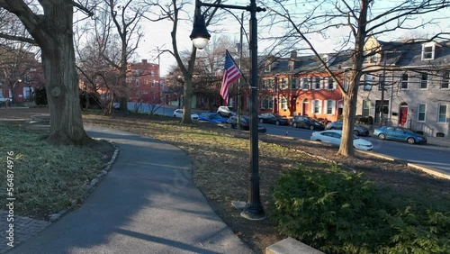 Aerial view of American flag waving on cold winter day in park beside city housing. photo