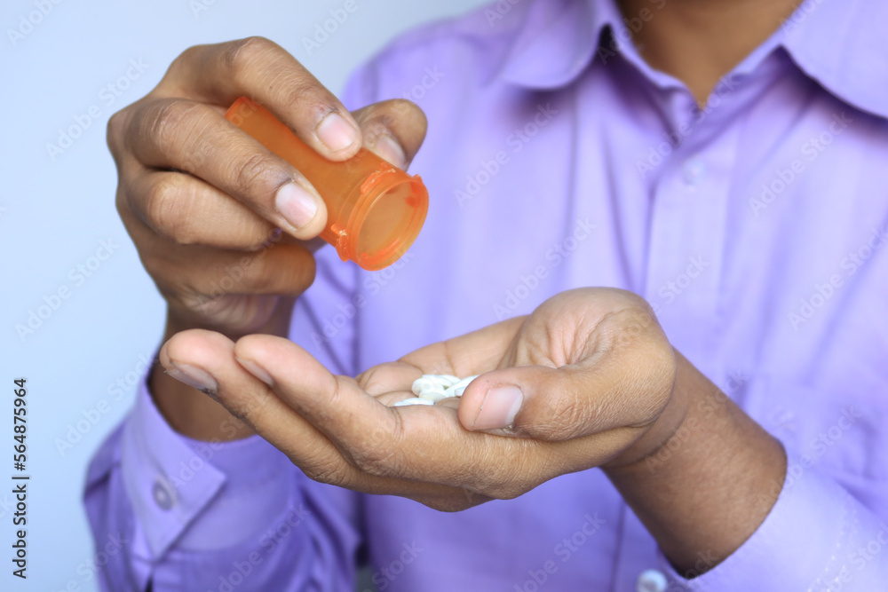 Fototapeta premium man's hand with medicine spilled out of the pill container 