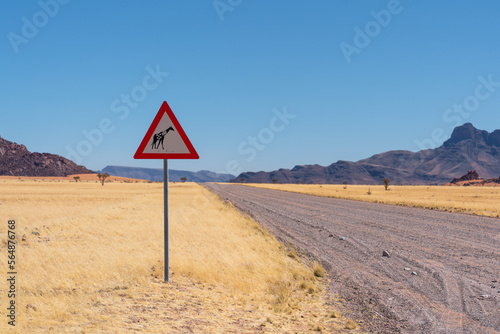 Giraffe crossing danger sign in a grassy plain in Namibia, Africa