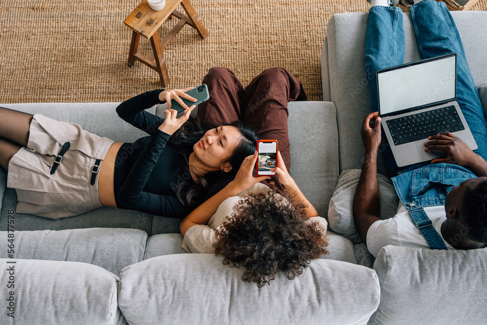 © Momento Estudio/Stocksy - asian girl smiling while looking at the mobile with her friends