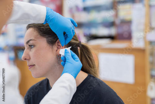 Woman having ear piercing process photo