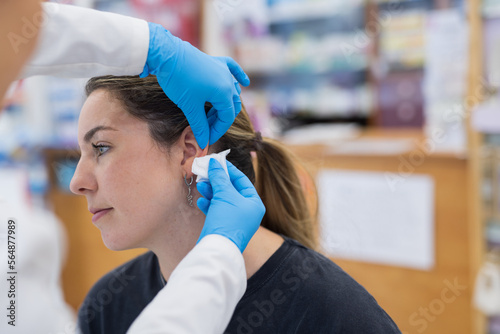 Woman having ear piercing process
