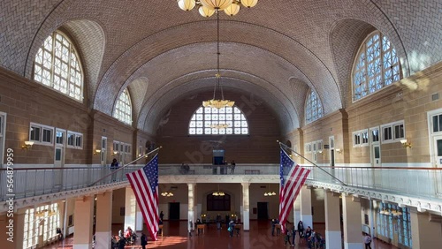 several tourists visit the hall of the former border post on Ellis Island. Indoor steady shot photo