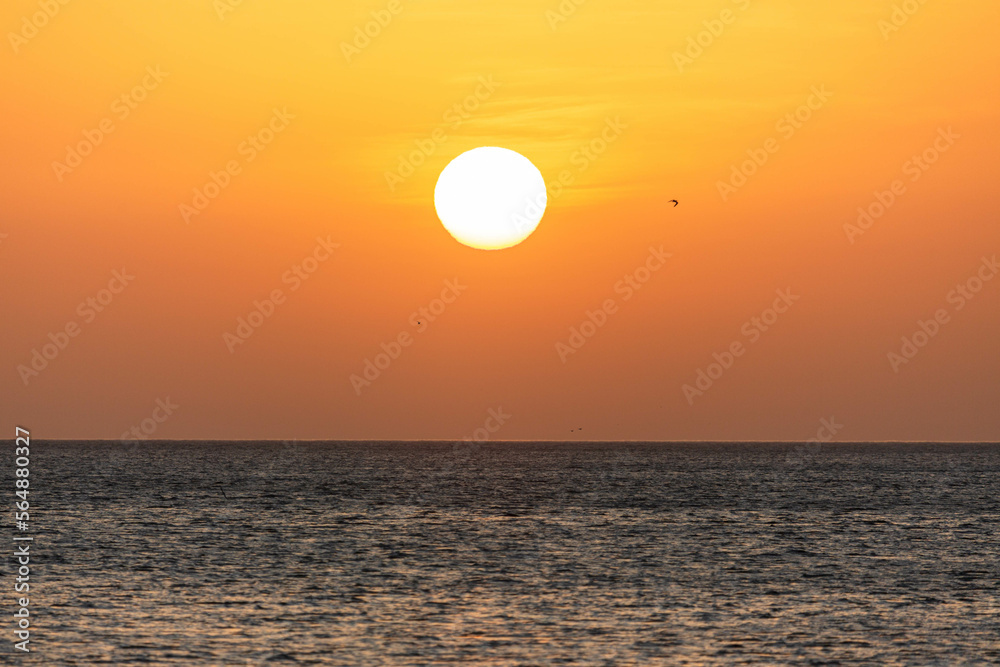 Sunrise with sun and orange sky, blue water of sea. Wallpaper