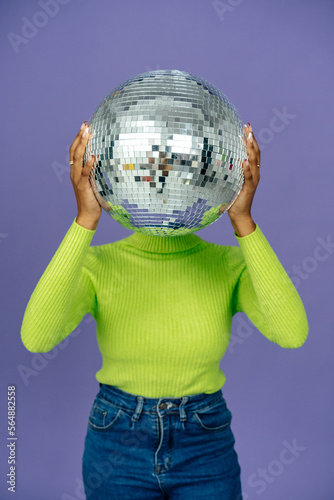 Female holding mirror ball instead of head in studio photo