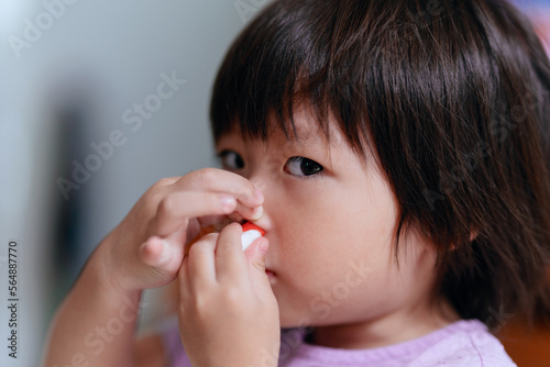 Child uses tissue to stop nosebleed photo