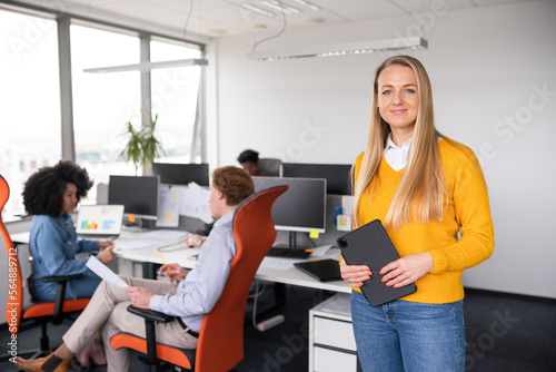 Portrait Of Woman Holding Tablet At Office 